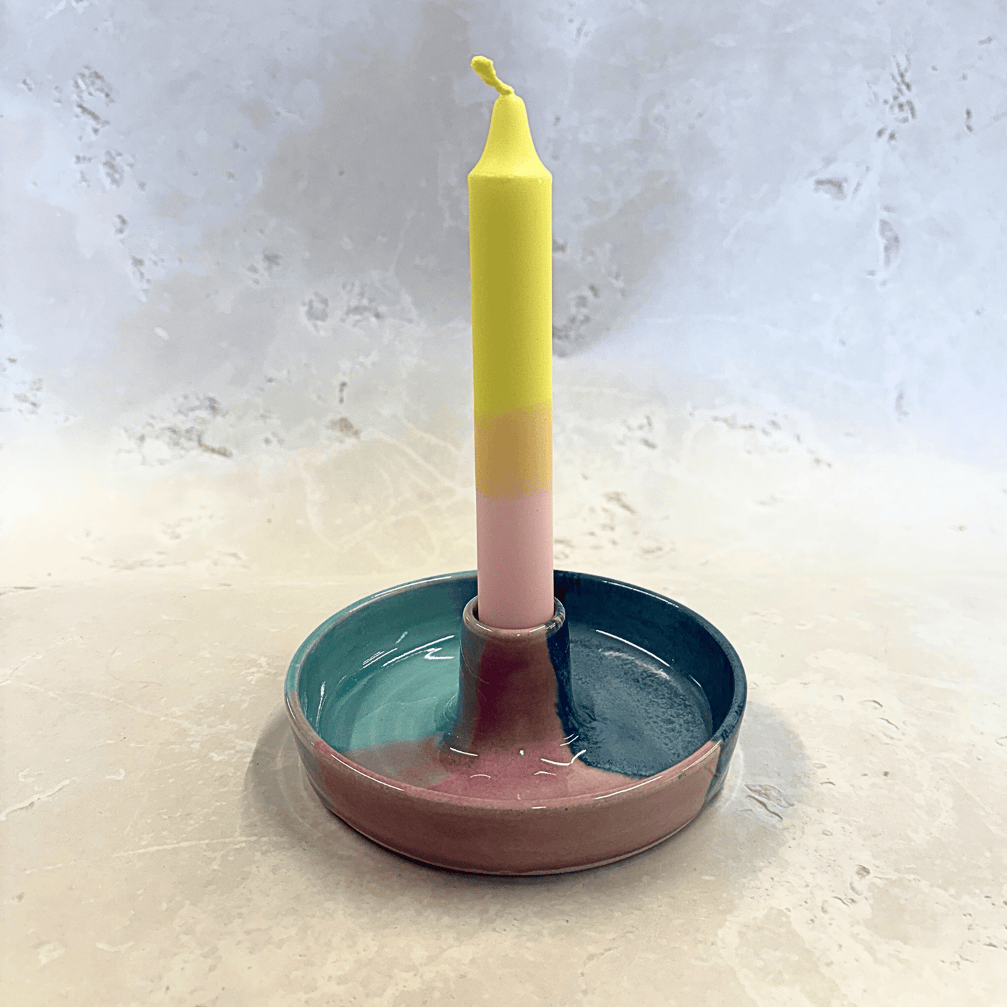 Ella Fletcher Designs Handmade Ceramic Candlestick holder in Scottish Sunrise Landscape design, circular candlestick holder with layered dark and light blues and pink featuring a candle