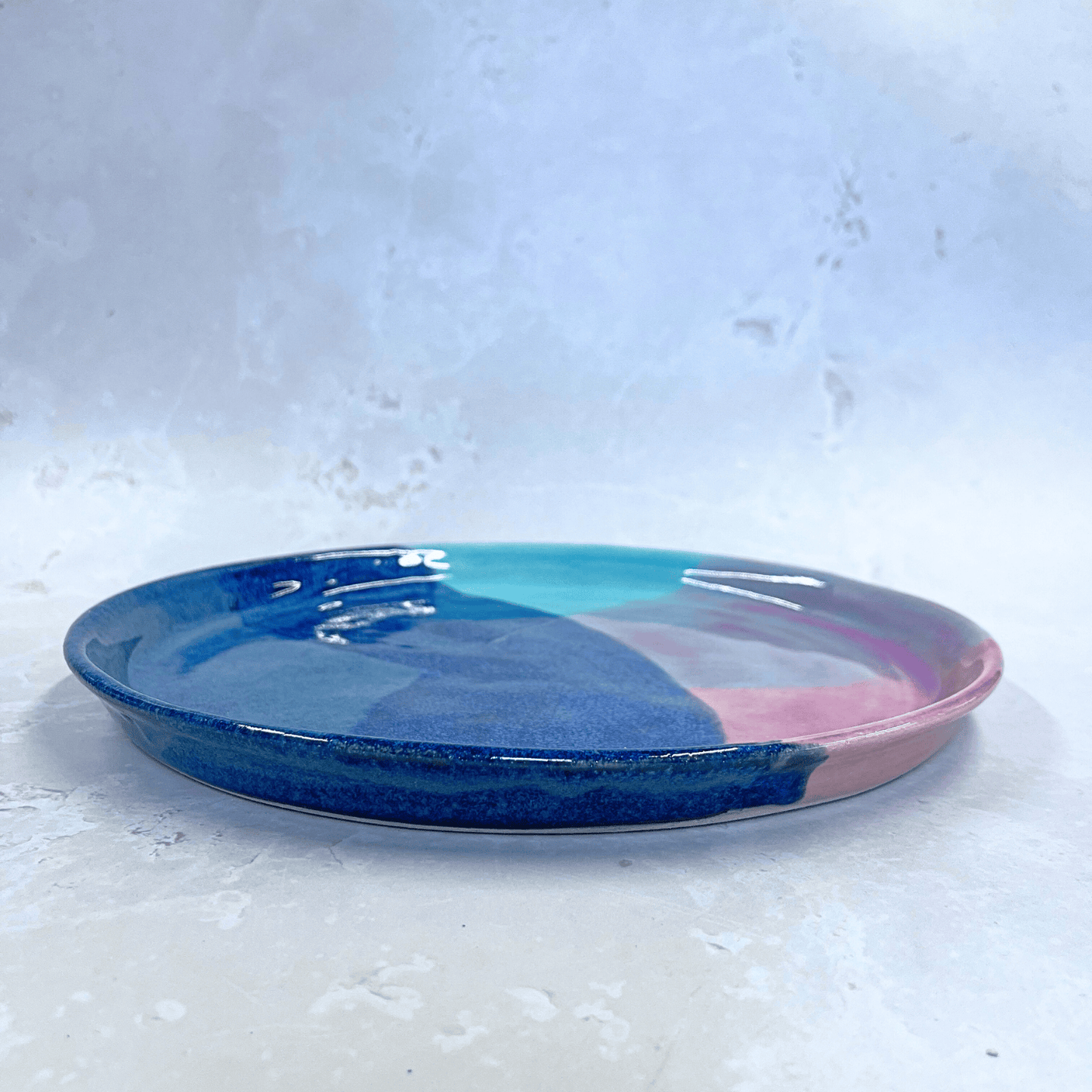 Ella Fletcher Designs Handmade Ceramic Dinner Plate in Scottish Sunrise Landscape, circular plate with layers of pinks and blues inspired by Scottish Sunrises, side view