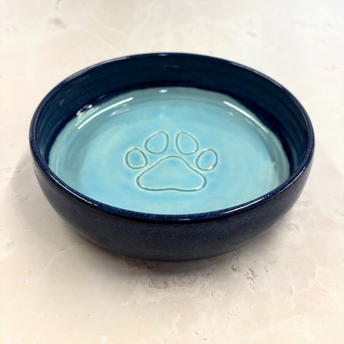 Ella Fletcher Designs handmade Blue ceramic pet bowl with a paw print design on a light background