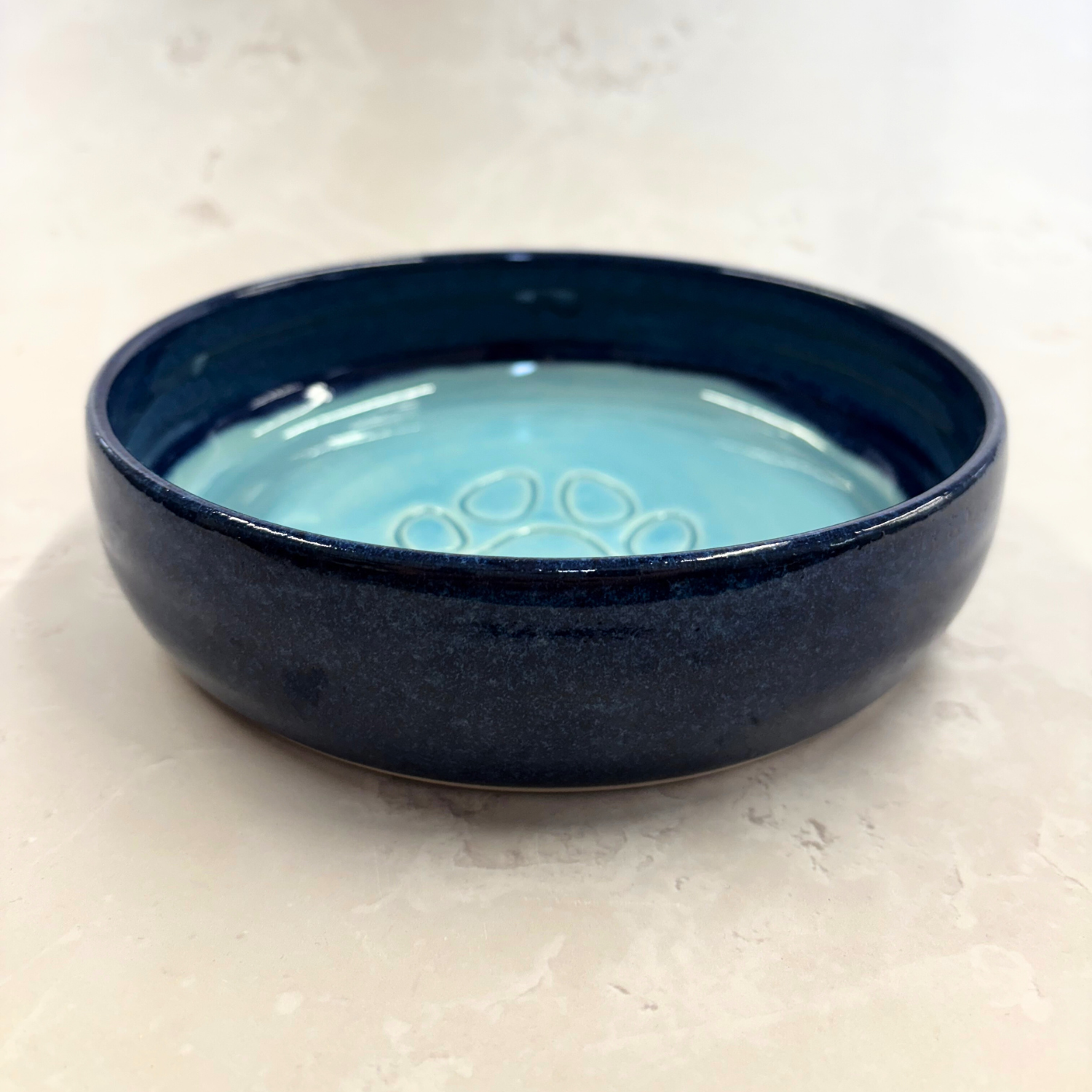 Ella Fletcher Designs handmade Blue ceramic bowl with a light blue interior on a beige surface
