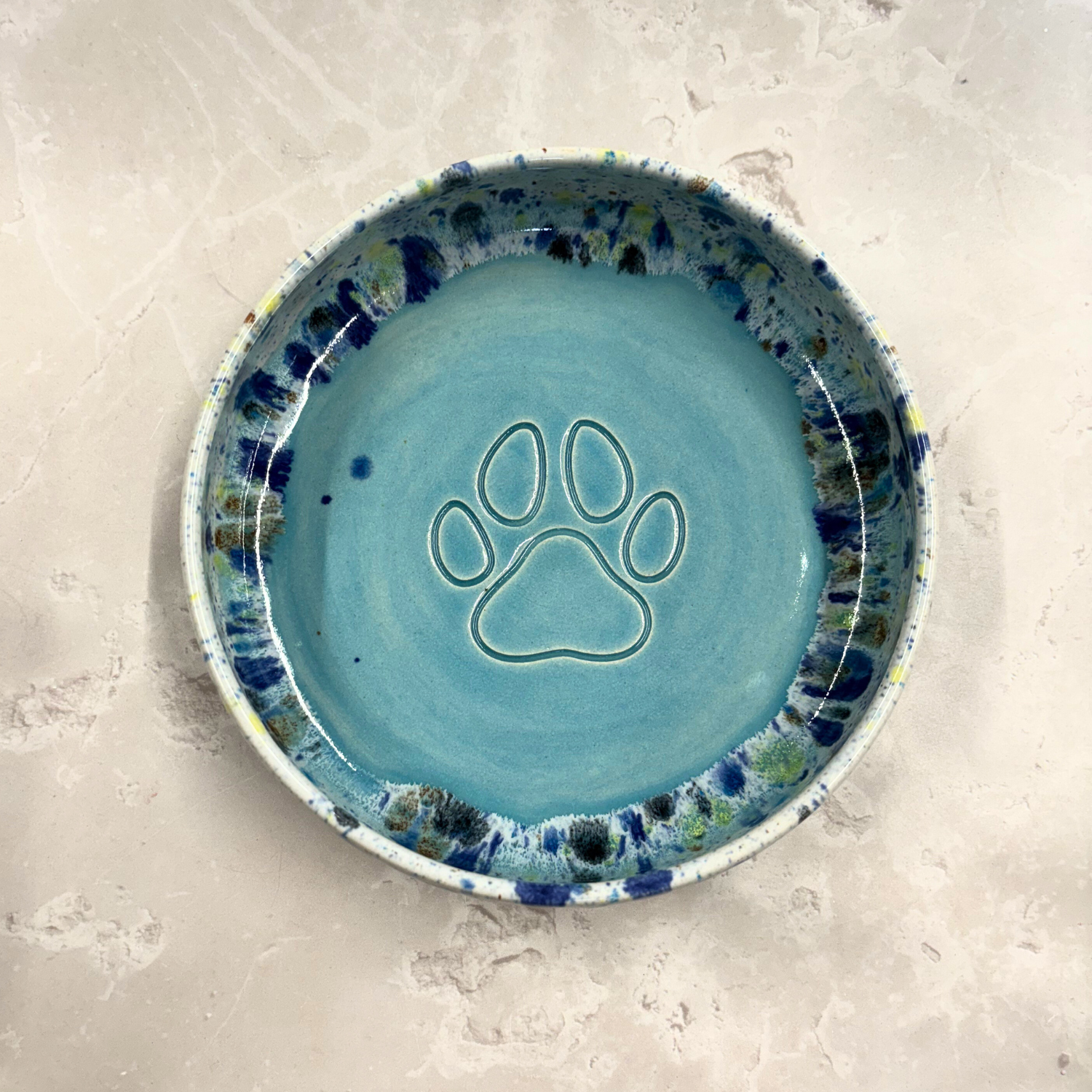 Ella Fletcher Designs handmade Blue ceramic bowl with a paw print design on a light gray background