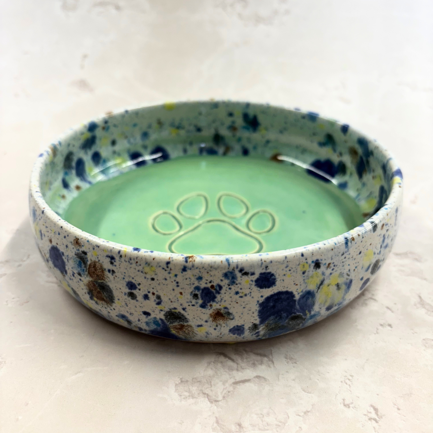 Ella Fletcher Designs handmade Speckled ceramic bowl with paw print design on a light background