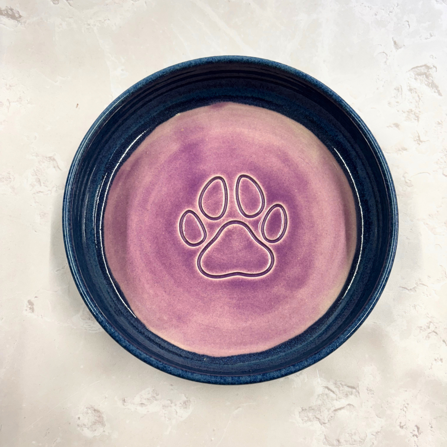 Ella Fletcher Designs handmade Pet bowl with purple interior and blue exterior on a light gray background