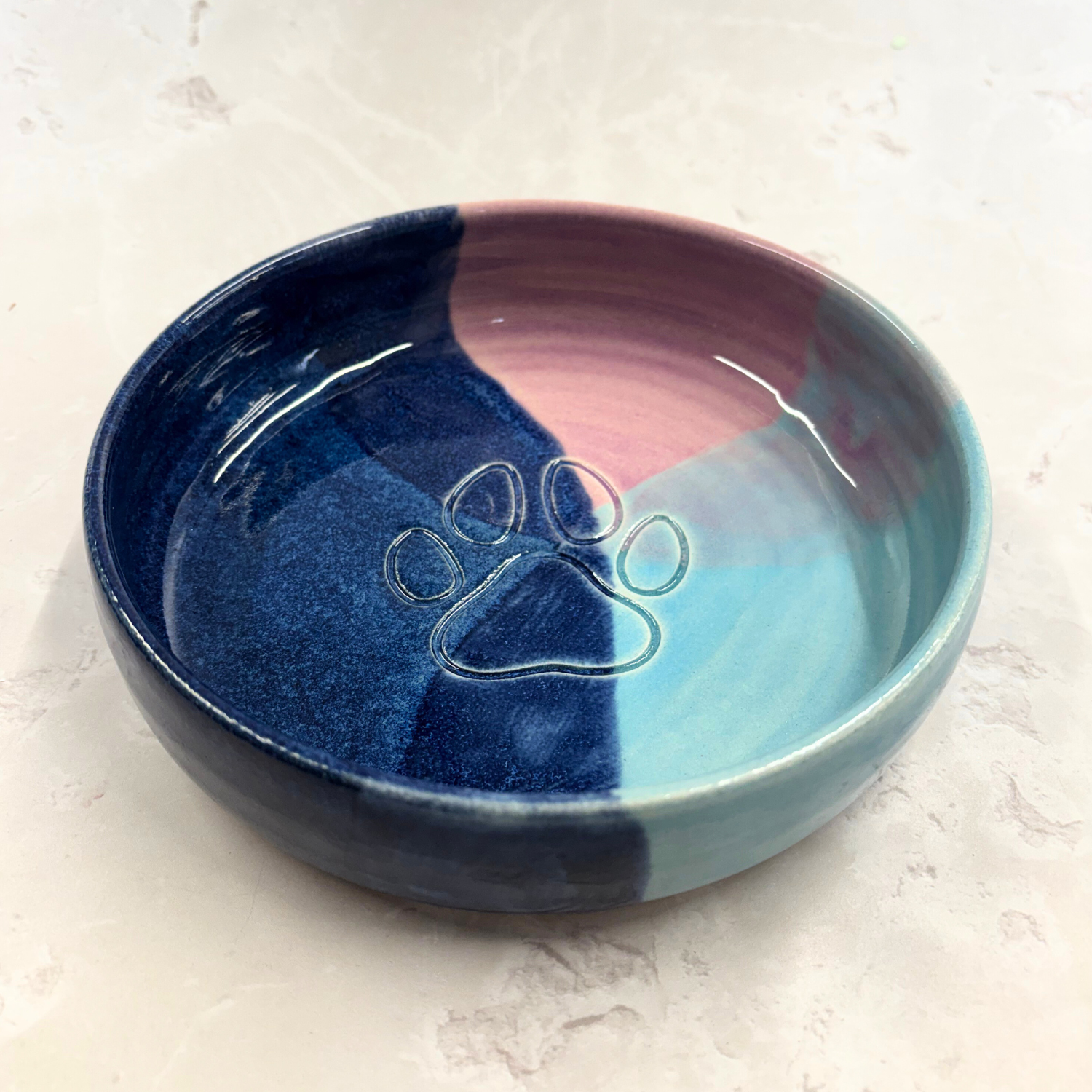 Ella Fletcher Designs handmade  Ceramic pet bowl with a paw print design on a light gray background