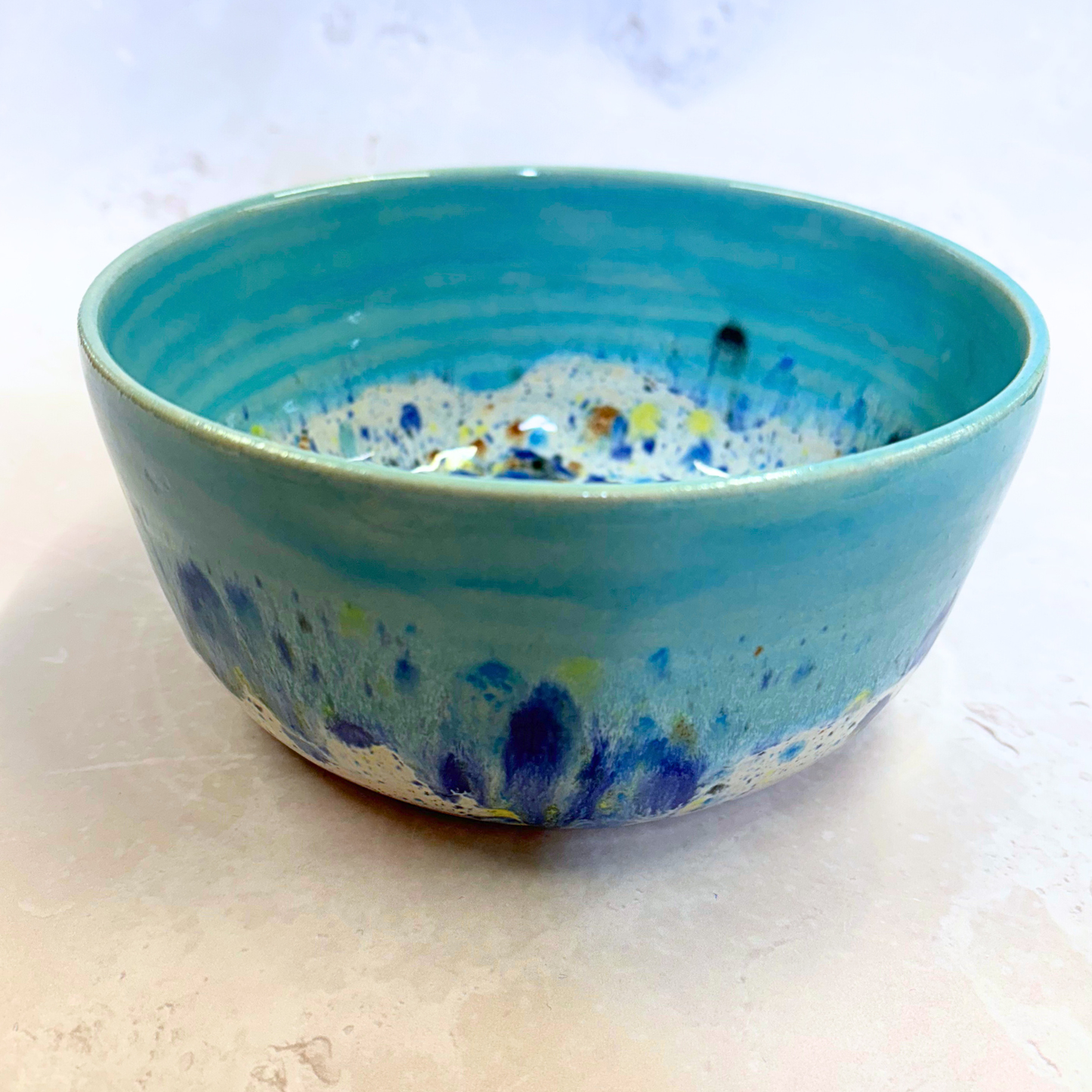 Ella Fletcher Designs Handmade Ramen Bowl in Blue Shoreline, bowl with solid blue melting into multi-coloured speckles on a white background