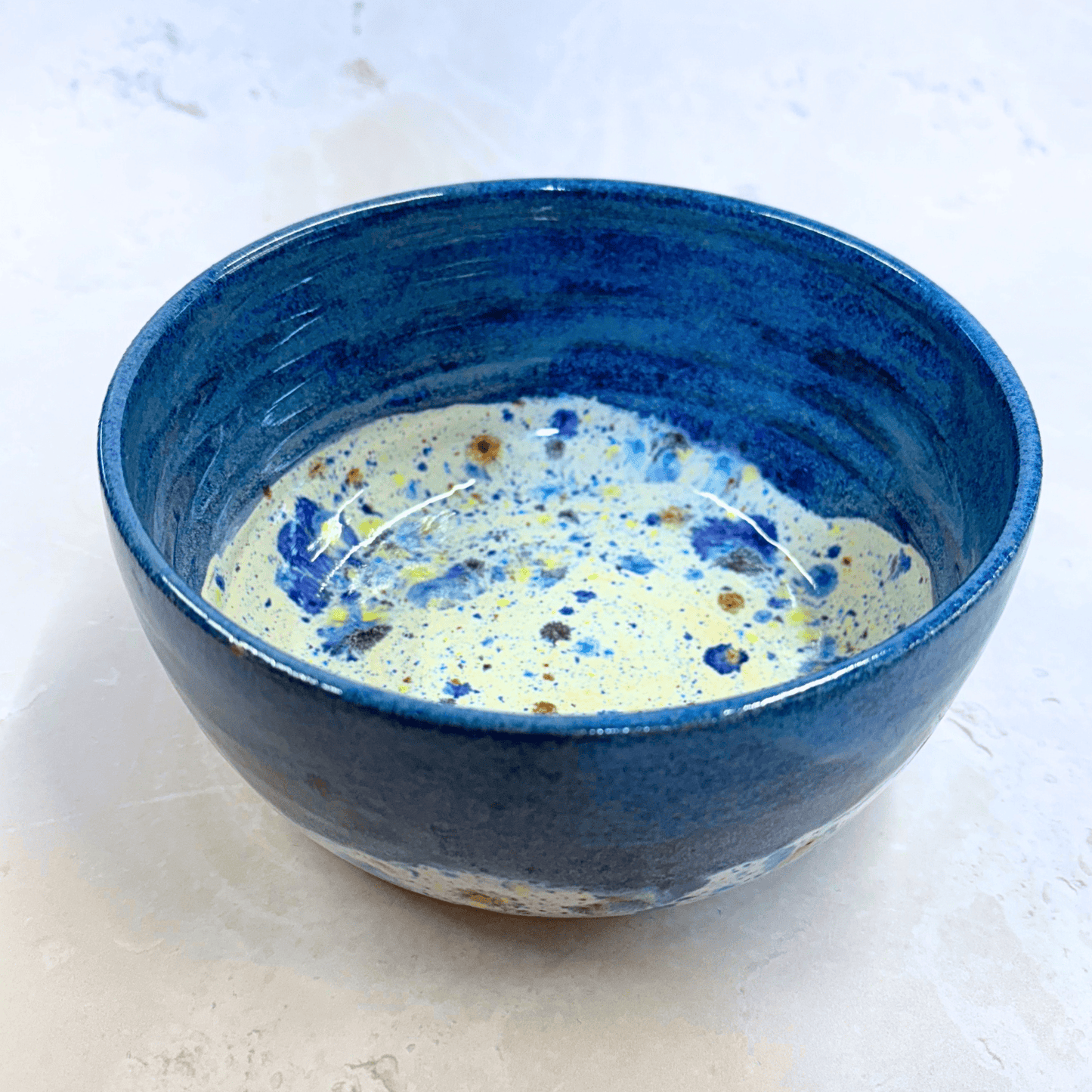 Ella Fletcher Designs Handmade Ramen Bowls in Navy Shoreline, bowl with solid navy melting into multi-coloured speckles on a white background