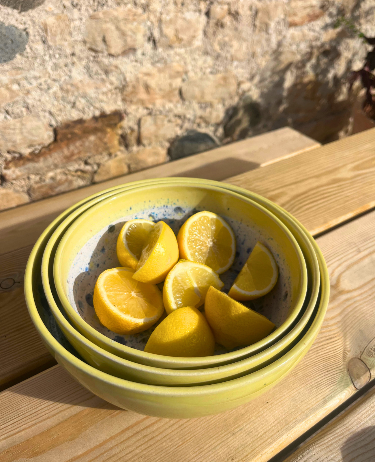 Yellow ceramic bowls with lemon slices on a wooden surface