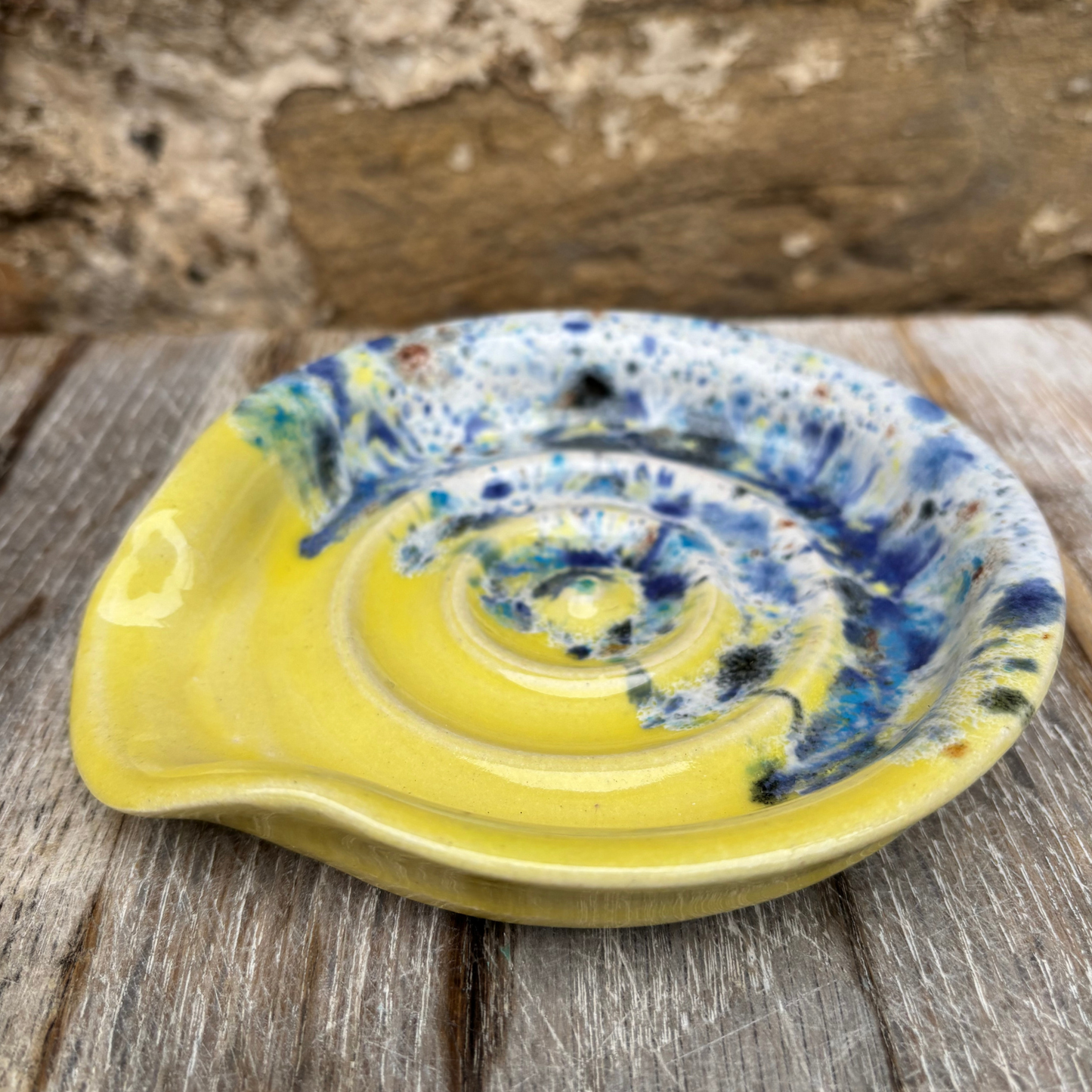 Ceramic dish with spiral design on a wooden surface