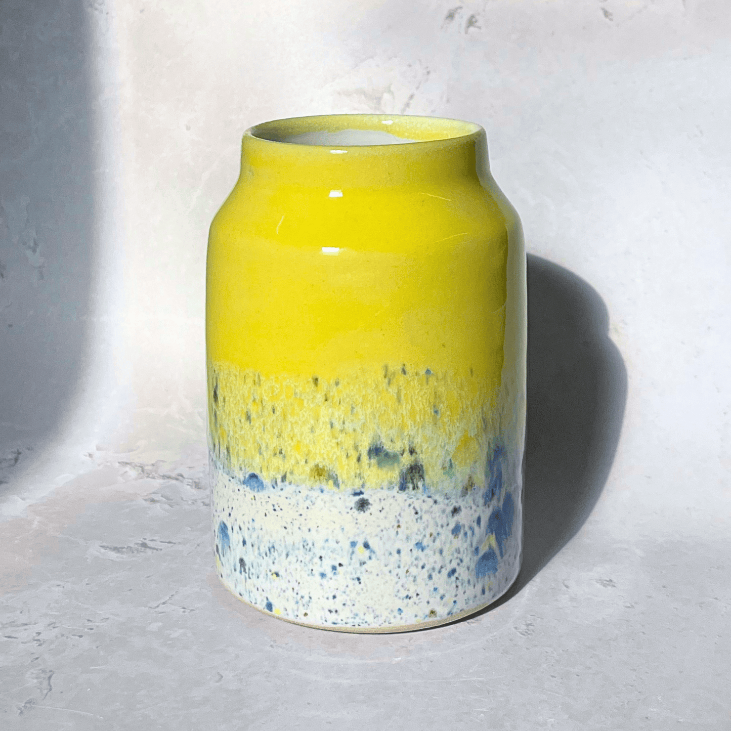 Ella Fletcher Designs Handmade Pottery Vase in Yellow Shoreline Design - vase with solid yellow top and multi-coloured speckles at the bottom