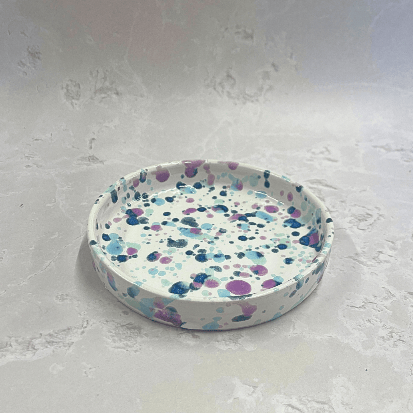 Ella Fletcher Designs Handmade Ceramic Trinket Dish in Sweetpea Design, white background of a small circular dish with speckles of blues and pink to resemble sweet pea flowers