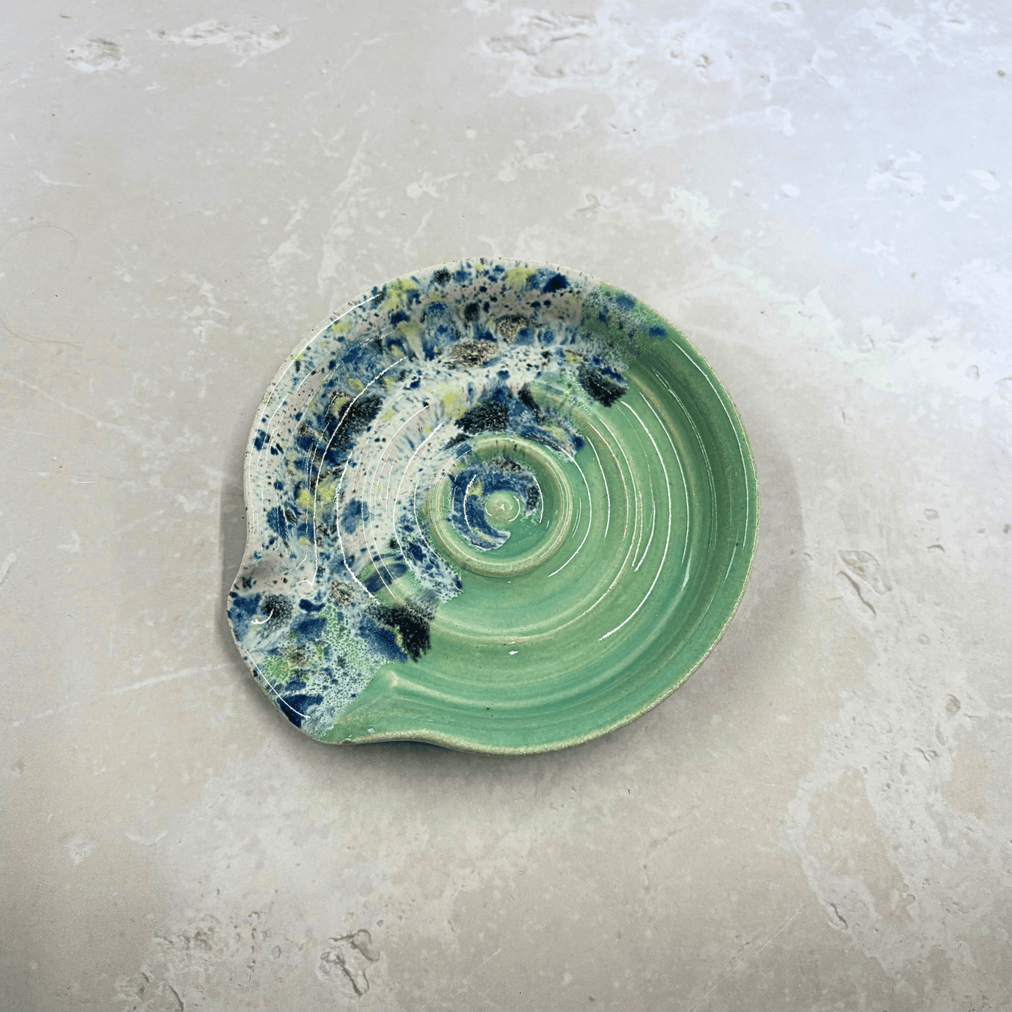 Ella Fletcher Designs Handmade Ceramics Spoon Rest in Green Shoreline, circular spoon rest with ridges, green and multi-coloured speckles