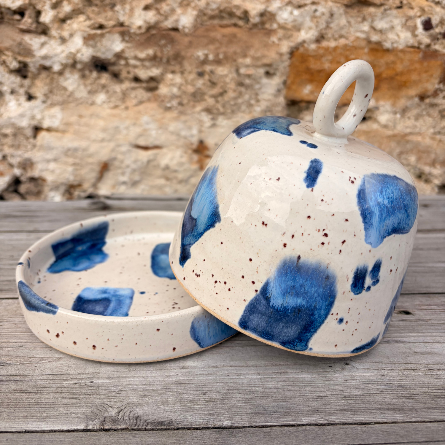 Ceramic dish with blue speckled design on a wooden surface