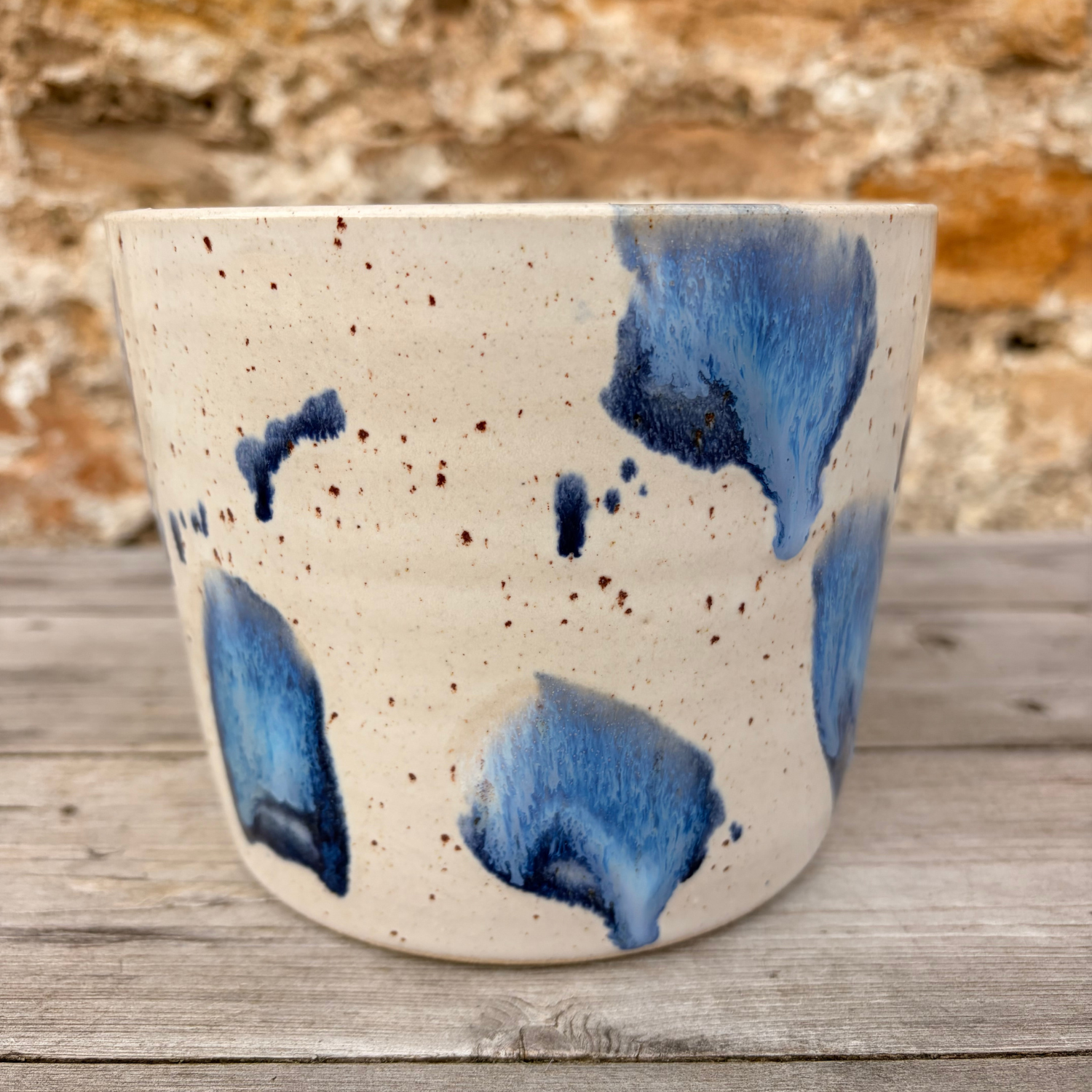 Ceramic pot with blue abstract designs on a wooden surface
