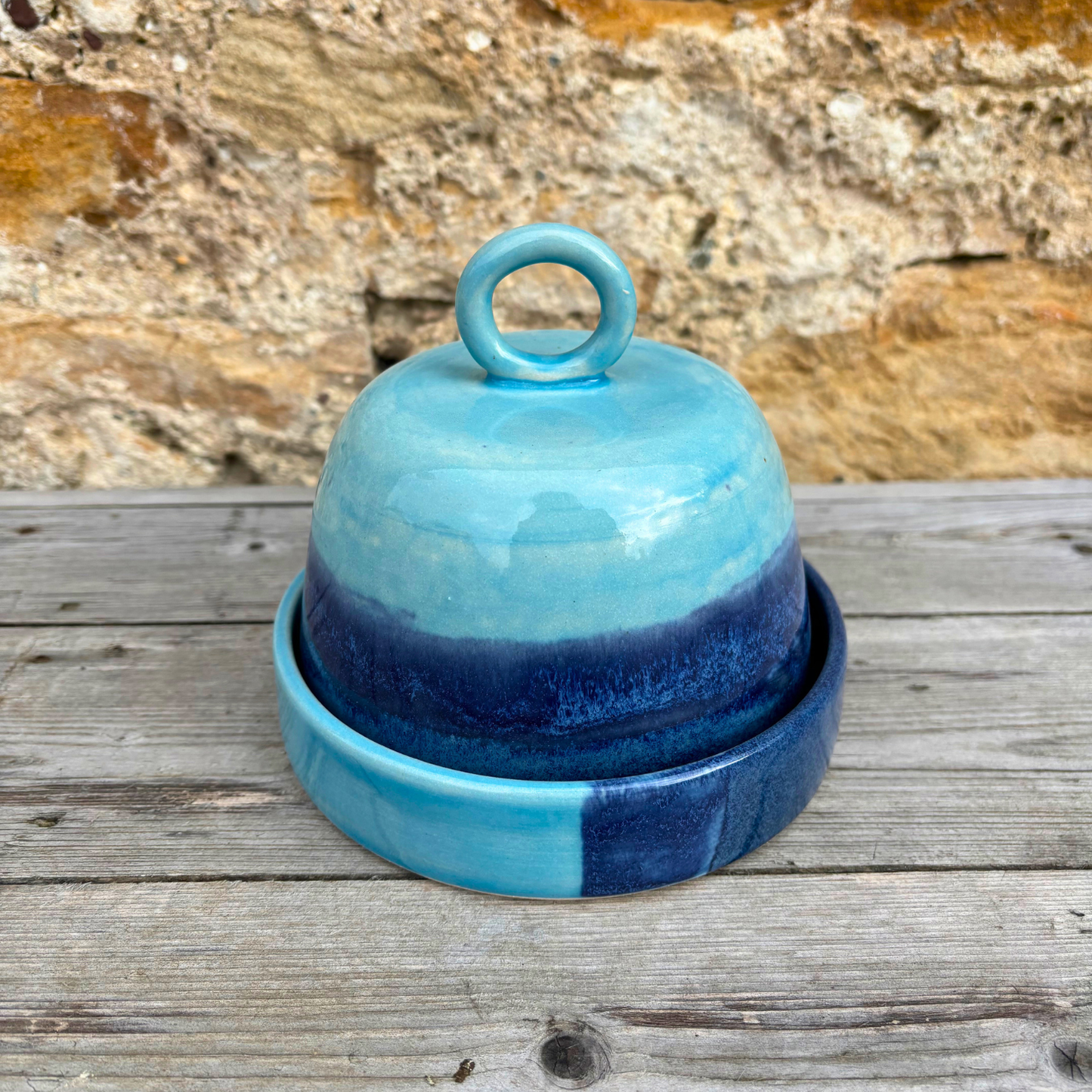 Blue ceramic container with a lid on a wooden surface