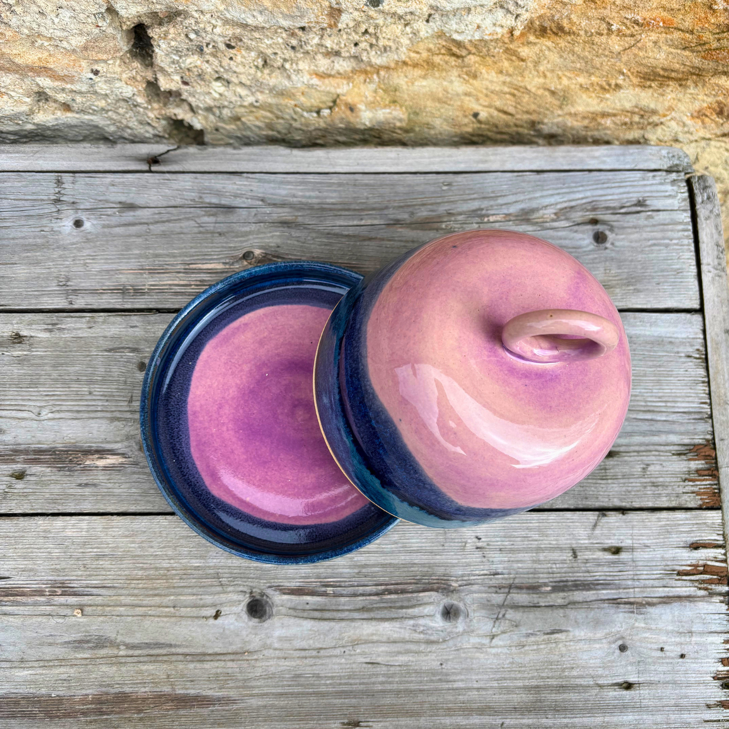 Two pink ceramic items with blue accents on a wooden surface.