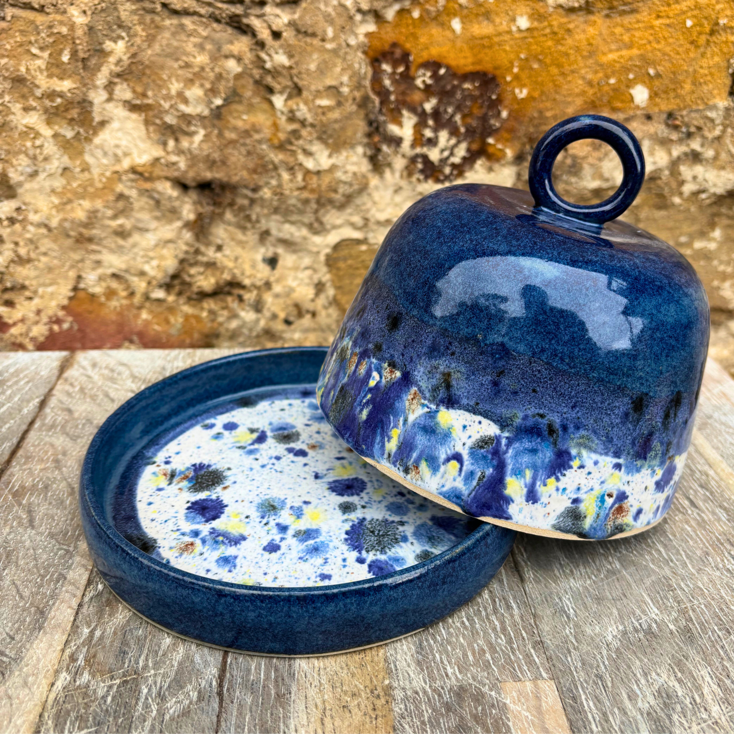 Blue ceramic lid with speckled design on a wooden surface
