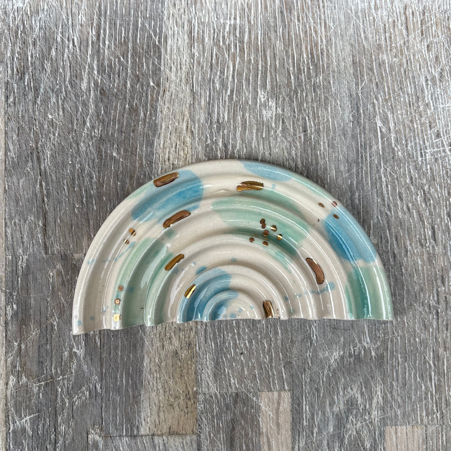 Ceramic soap dishes with rainbow pattern on a gray surface