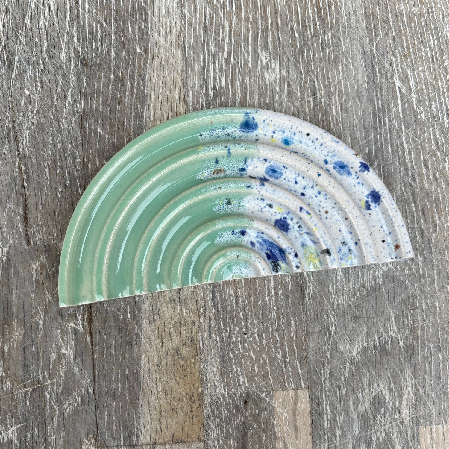 Decorative ceramic soap dish with concentric circular patterns on a wooden surface
