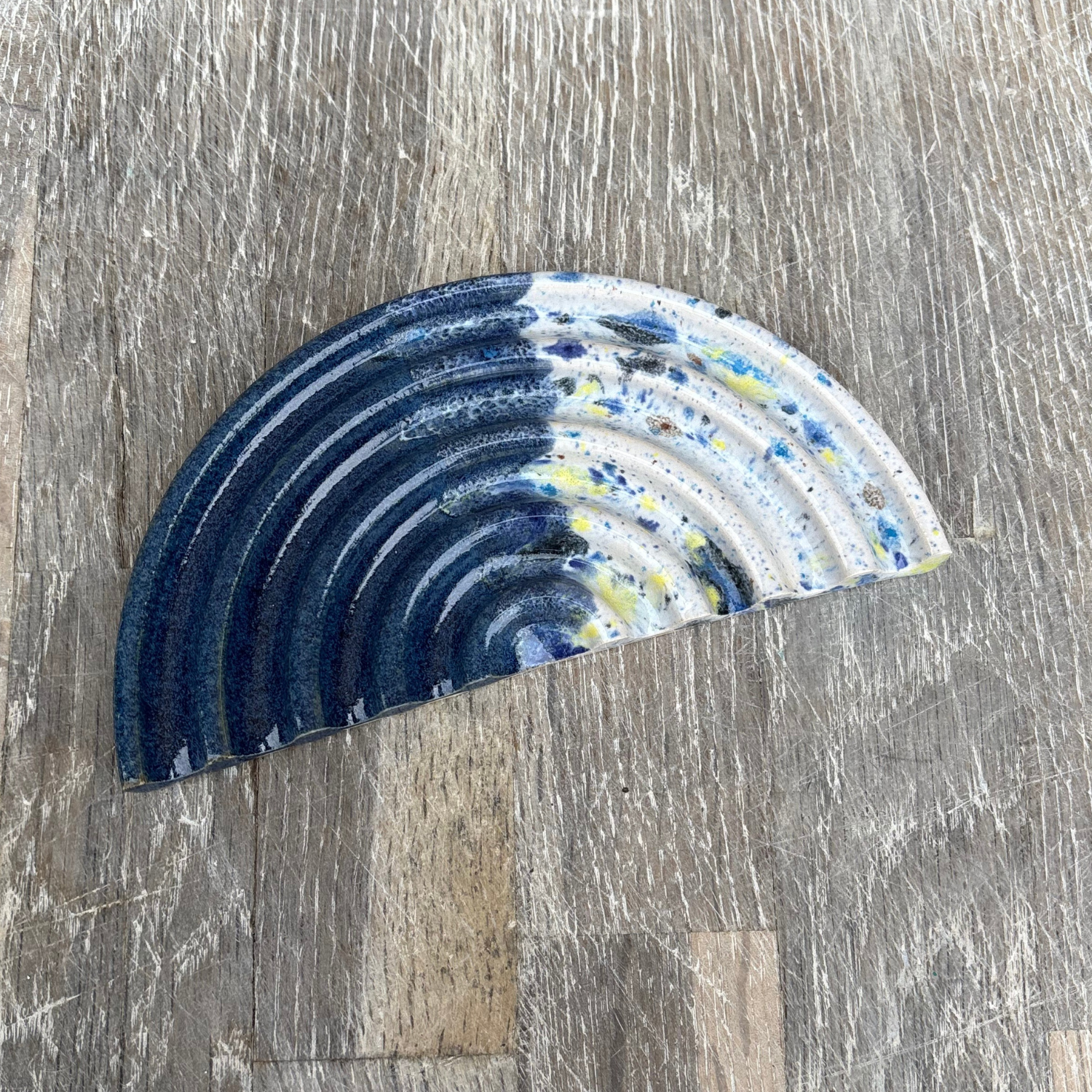 Decorative ceramic soap dish with blue and white pattern on a wooden surface