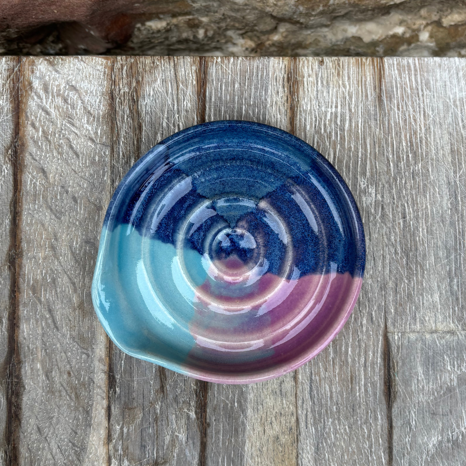 Multicolored ceramic spon rest on a wooden surface