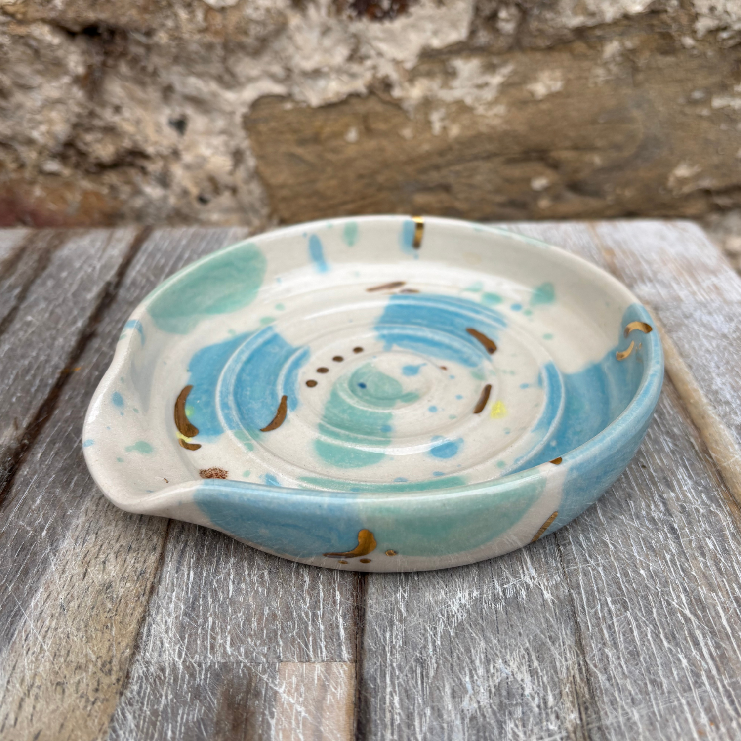 Ceramic dish with blue and white spiral design on a wooden surface