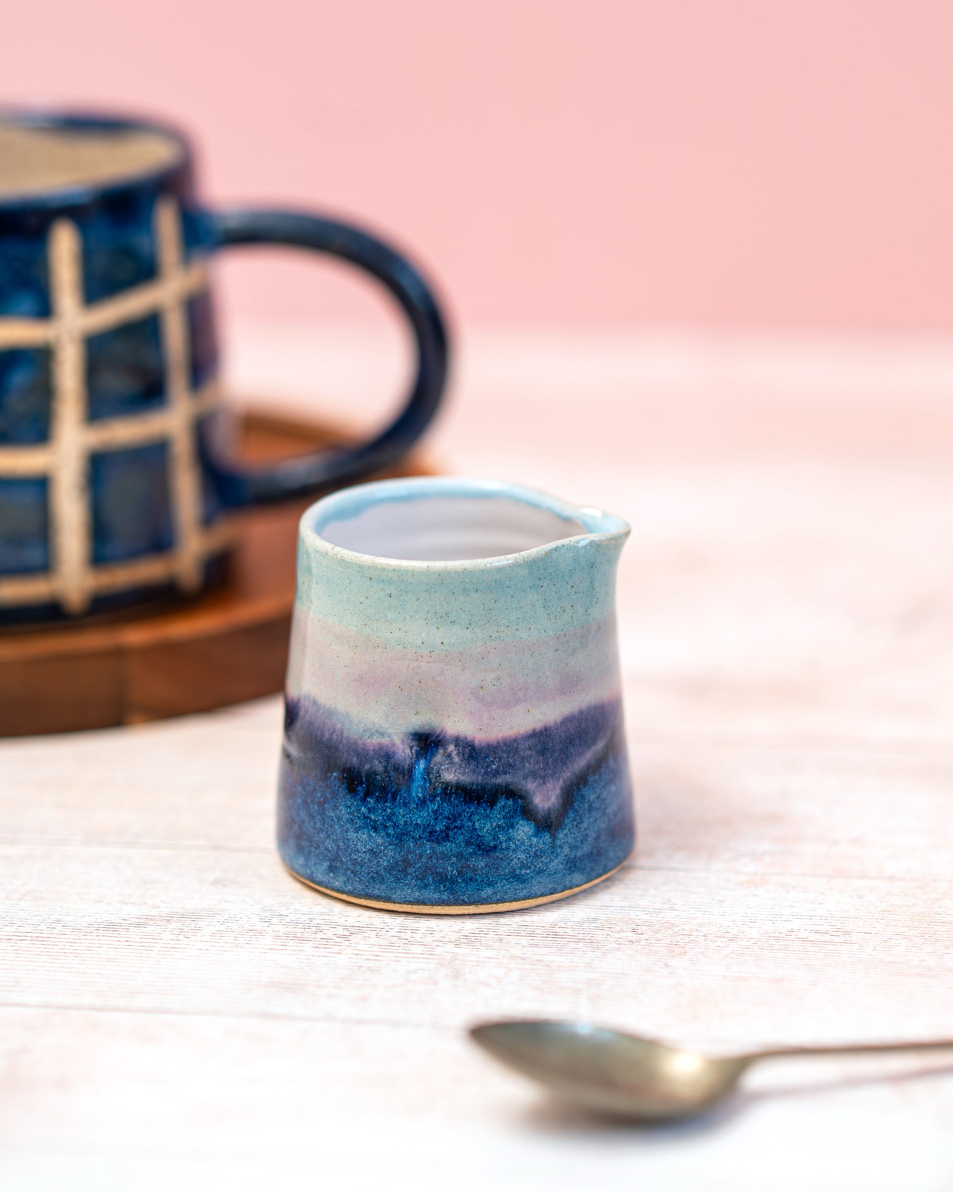 Ceramic mug with blue and purple gradient on a light pink background