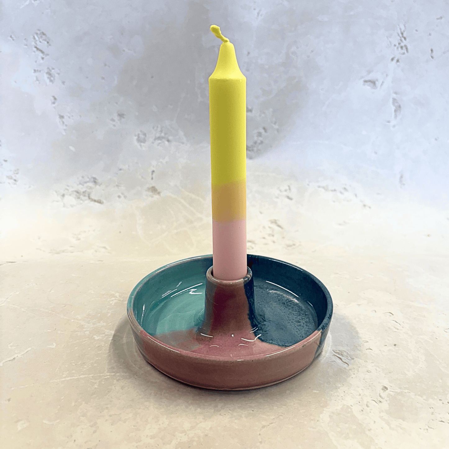 Ella Fletcher Designs Handmade Ceramic Candlestick holder in Scottish Sunrise Landscape design, circular candlestick holder with layered dark and light blues and pink featuring a candle