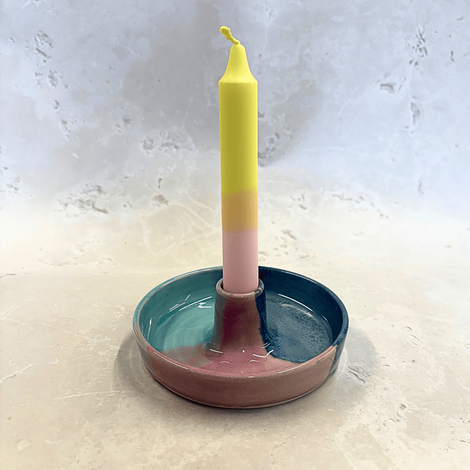 Ella Fletcher Designs Handmade Ceramic Candlestick holder in Scottish Sunrise Landscape design, circular candlestick holder with layered dark and light blues and pink featuring a candle