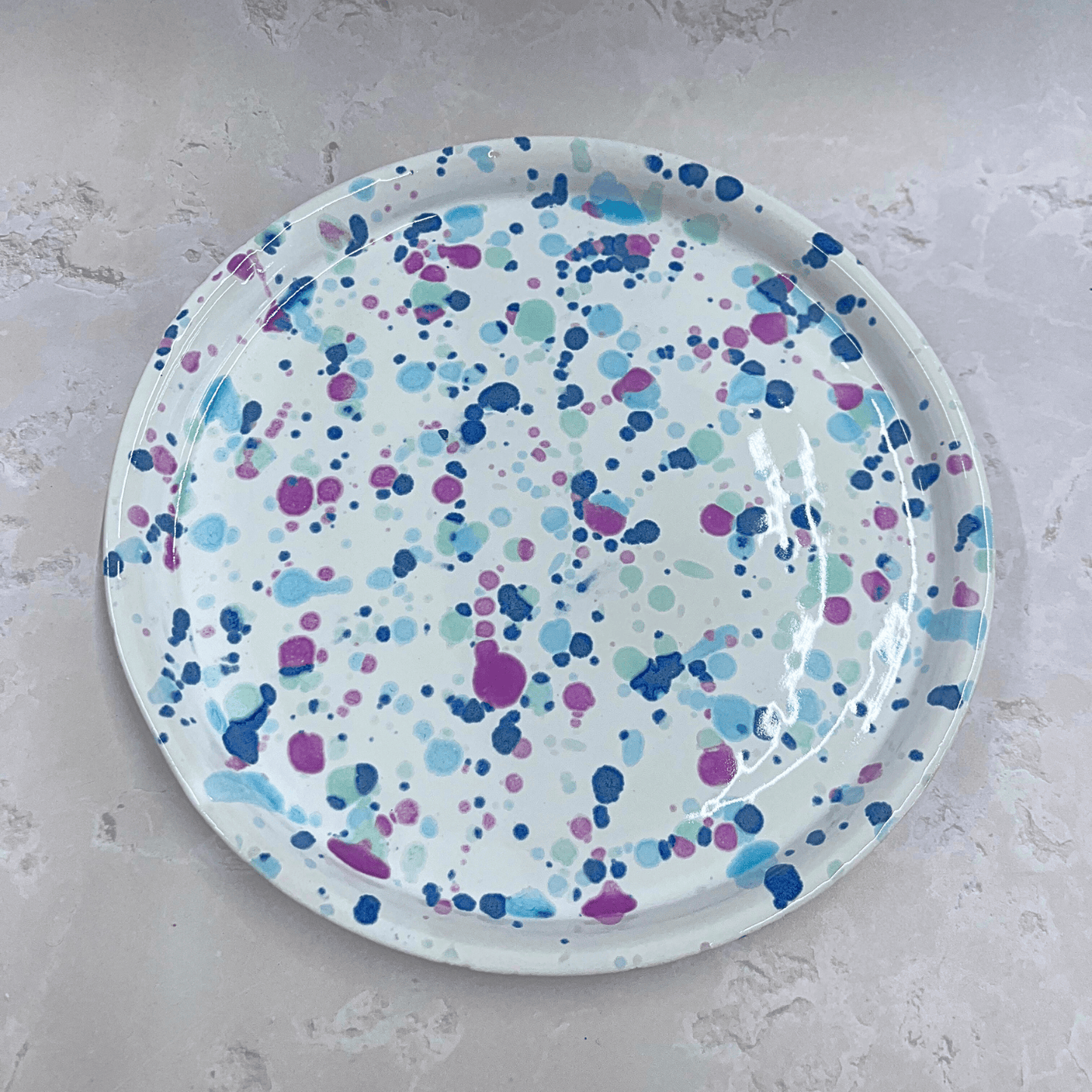 Ella Fletcher Designs Handmade UK Ceramic Dinner Plate in Sweetpea design, circular plate with white background speckled with pinks and blues to resemble a sweet pea flower