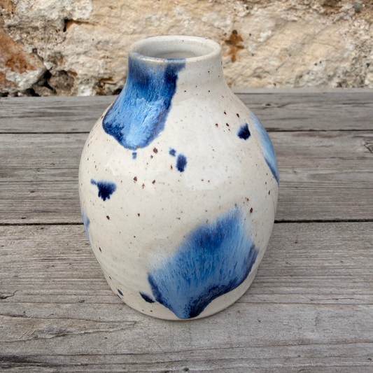 Ceramic vase with blue abstract patterns on a wooden surface
