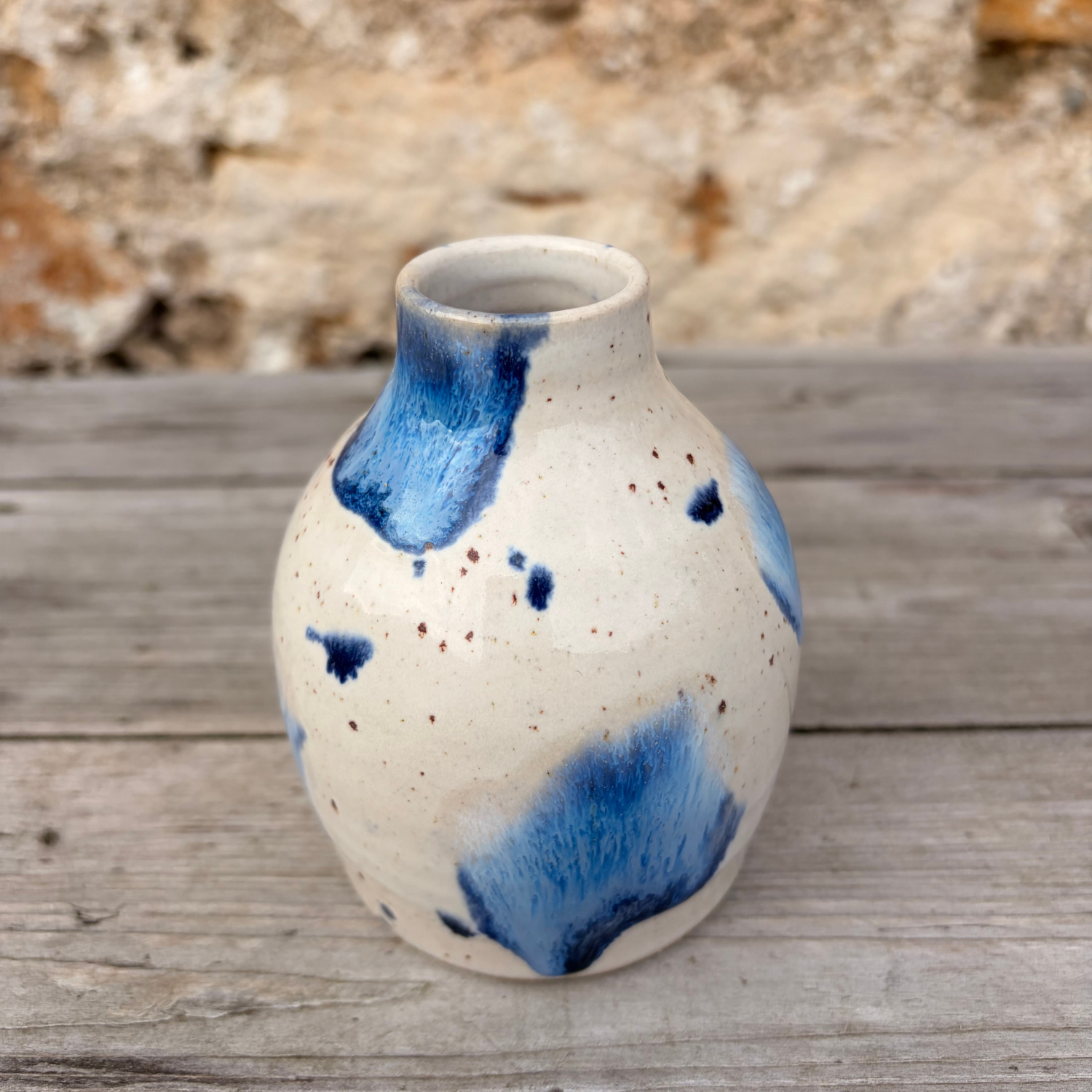 Ceramic vase with blue abstract patterns on a wooden surface