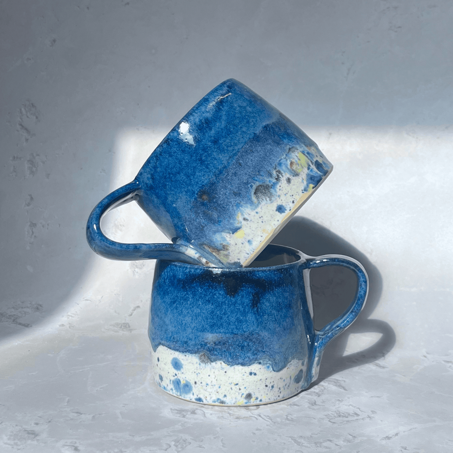 Ella Fletcher Designs Handmade Pottery Large Round Mug in Navy Blue Shoreline Design, solid blue on a round handmade mug with speckled multicolour design 