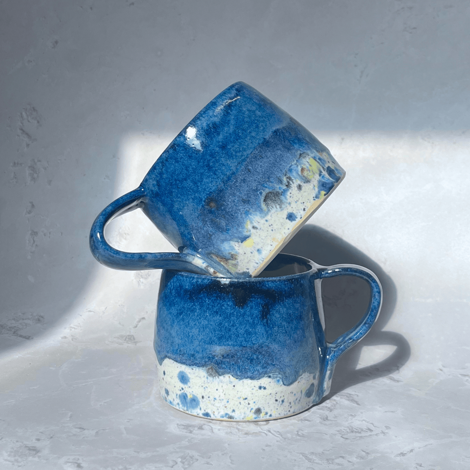 Ella Fletcher Designs Handmade Pottery Large Round Mug in Navy Blue Shoreline Design, solid blue on a round handmade mug with speckled multicolour design 