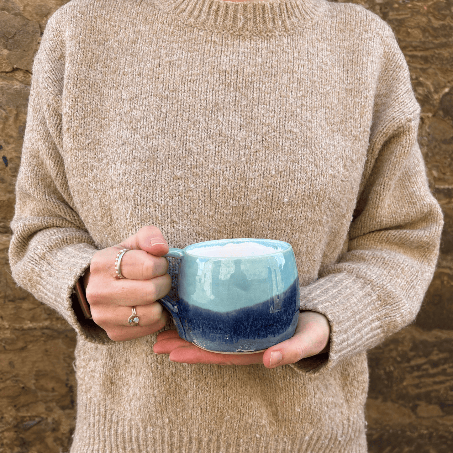 Ella Fletcher Designs Handmade Ceramic Large Round Mug in Pink Landscape design, large mug being held featuring layers of light and dark blues