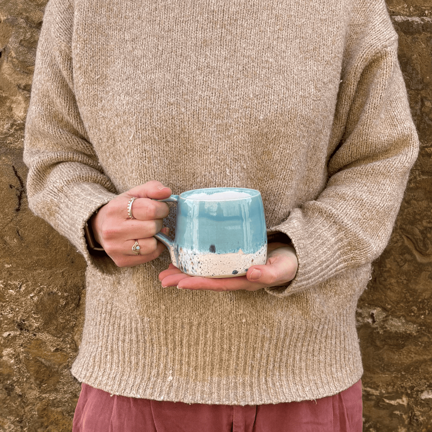 Ella Fletcher Designs Handmade Ceramic Mug in Blue Shoreline Design, round mug held with blue and multicolour speckle design