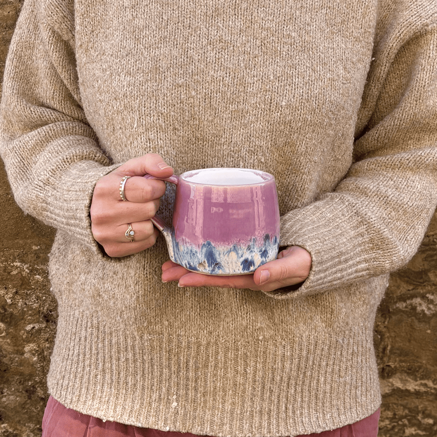 Ella Fletcher Designs Handmade Ceramic Mug in Pink Shoreline Design, round mug held with pink and multicolour speckle design