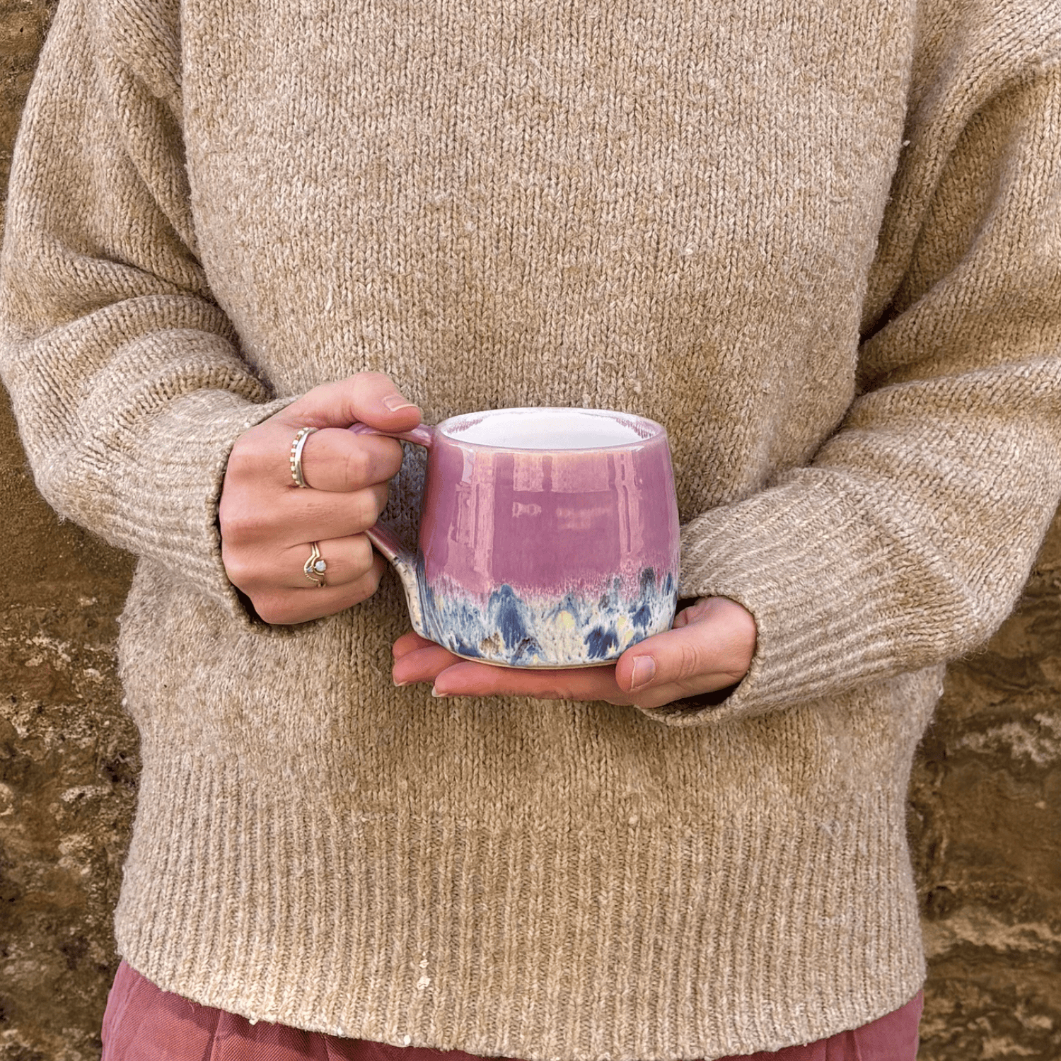 Ella Fletcher Designs Handmade Ceramic Mug in Pink Shoreline Design, round mug held with pink and multicolour speckle design