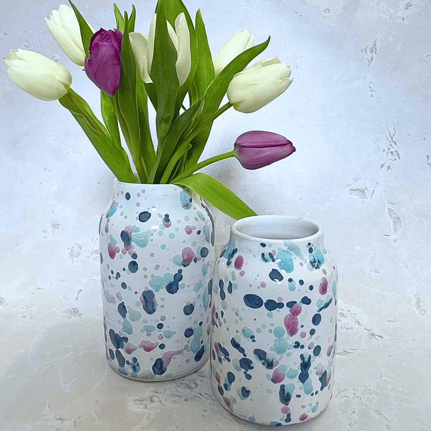 Ella Fletcher Designs Handmade Ceramic Vases in Sweetpea Design, two vases both with splatters of blues and pinks to resemble sweet pea flowers