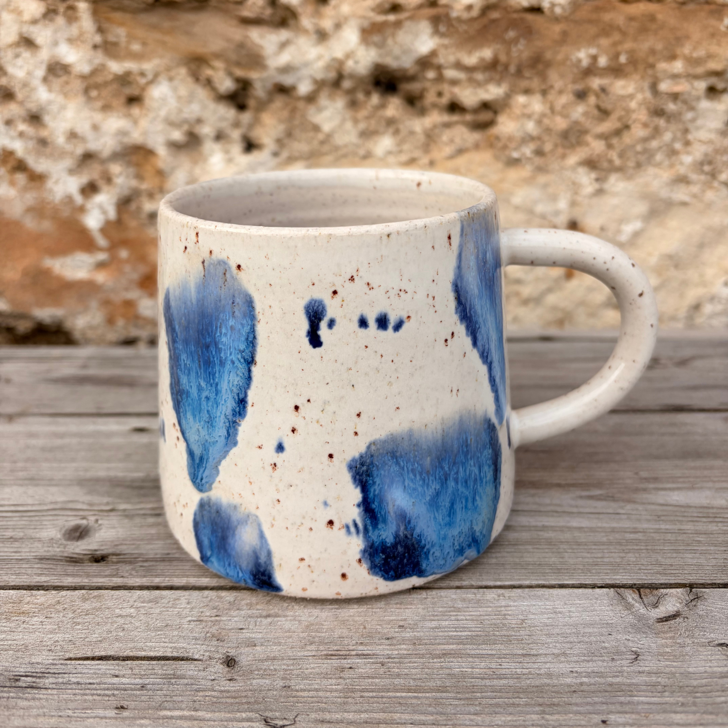 Ceramic mug with blue abstract design on a wooden surface