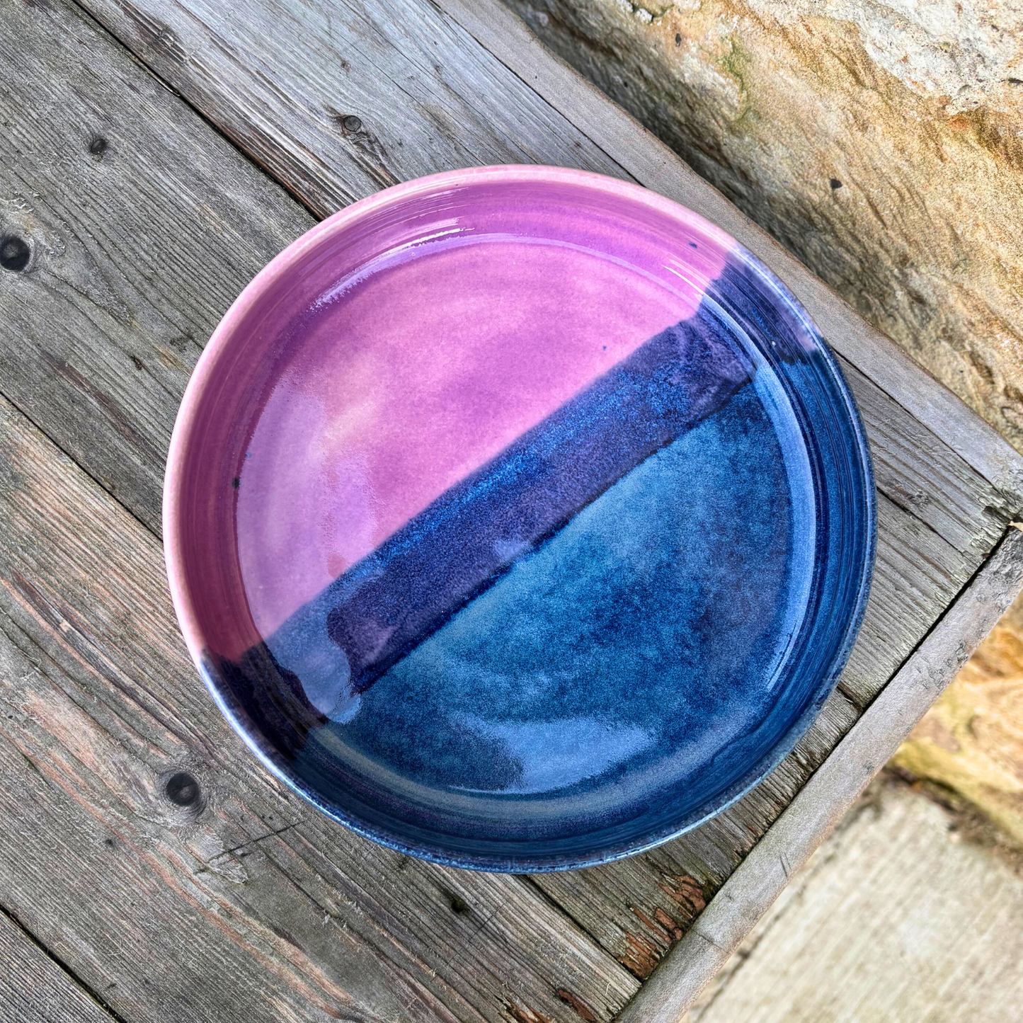Two-tone pink and blue ceramic bowl on a wooden surface
