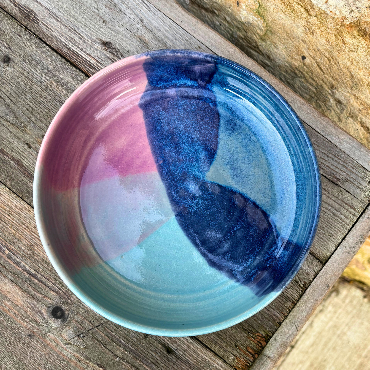 Colorful ceramic bowl with a gradient design on a wooden surface