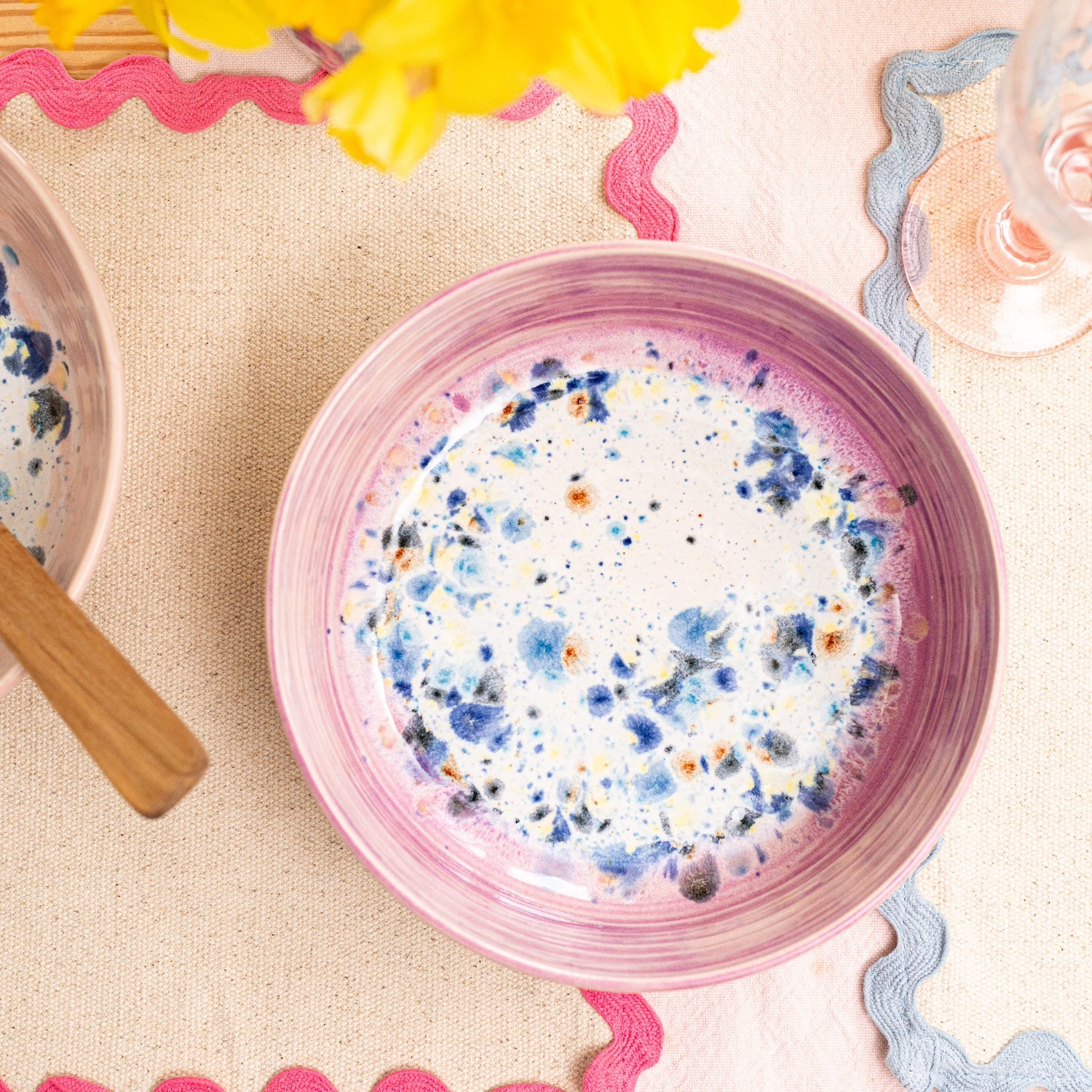 Ella Fletcher Designs Handmade Ceramic Pasta Bowl in Pink Shoreline, pink rim with multicoloured speckles inside, featured on a table