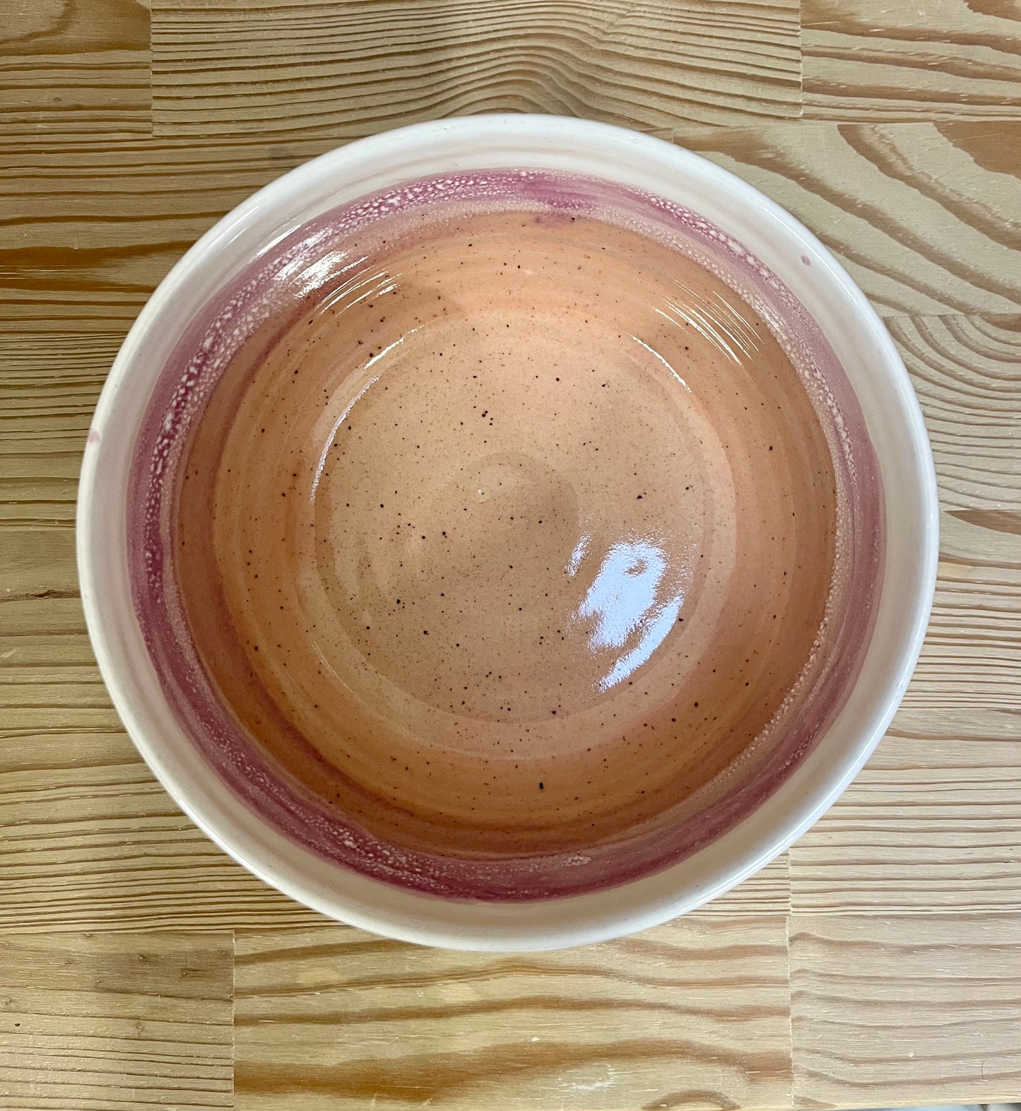 Ceramic bowl with a speckled design on a wooden surface