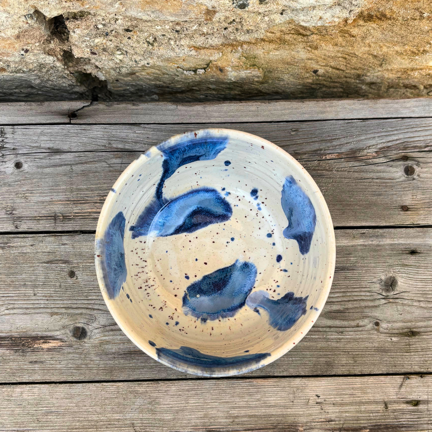 Ceramic bowl with blue abstract design on a wooden surface