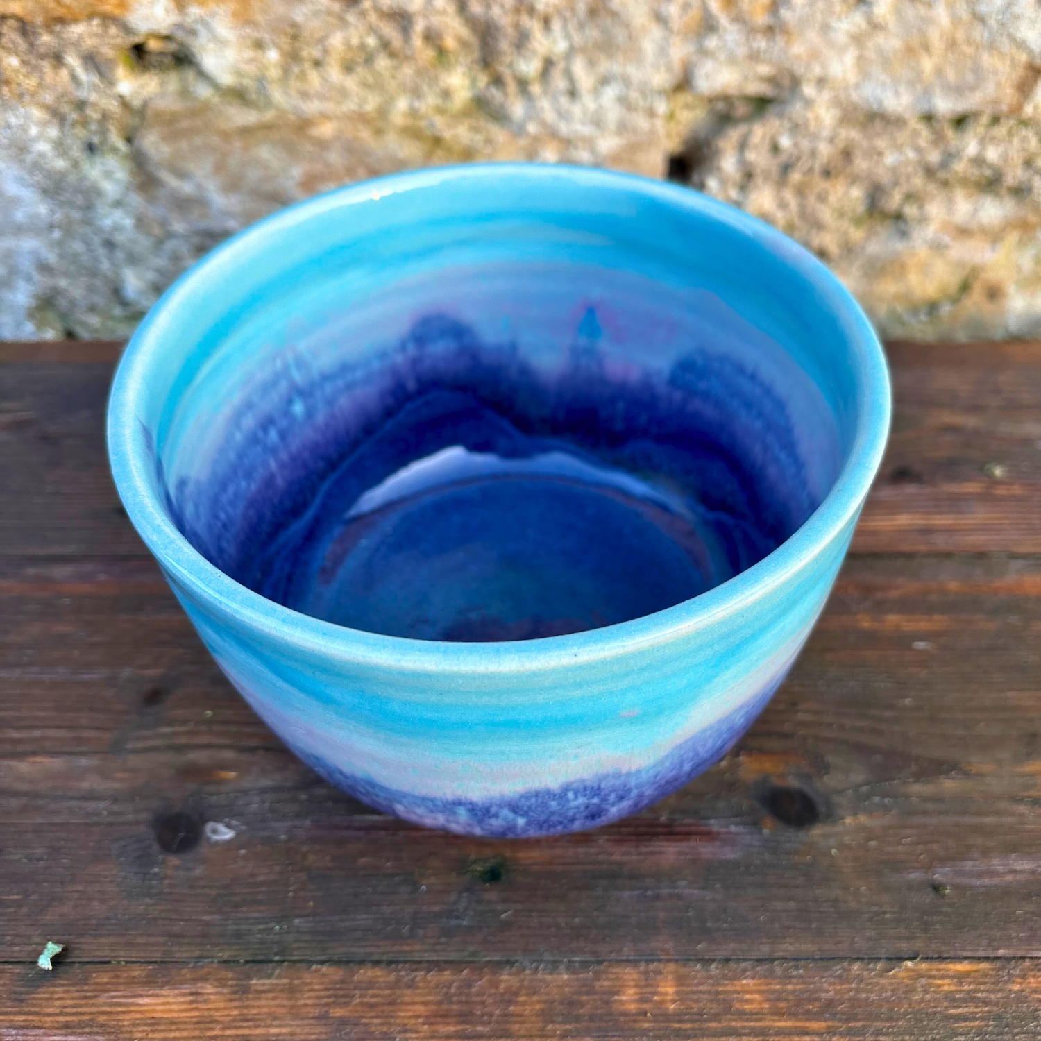 Blue ceramic bowl on a wooden surface with a natural background