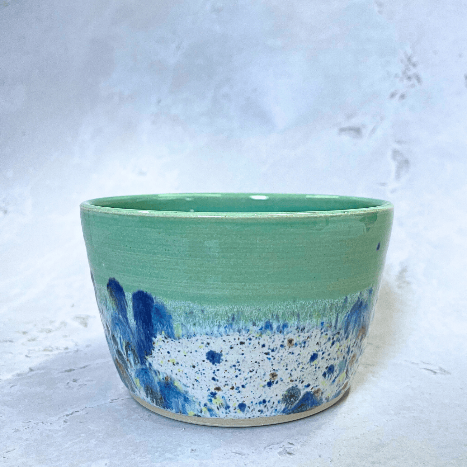 Ella Fletcher Designs Handmade Ceramic Small Bowl in Green Shoreline design, round green bowl with multicolour speckles, side view