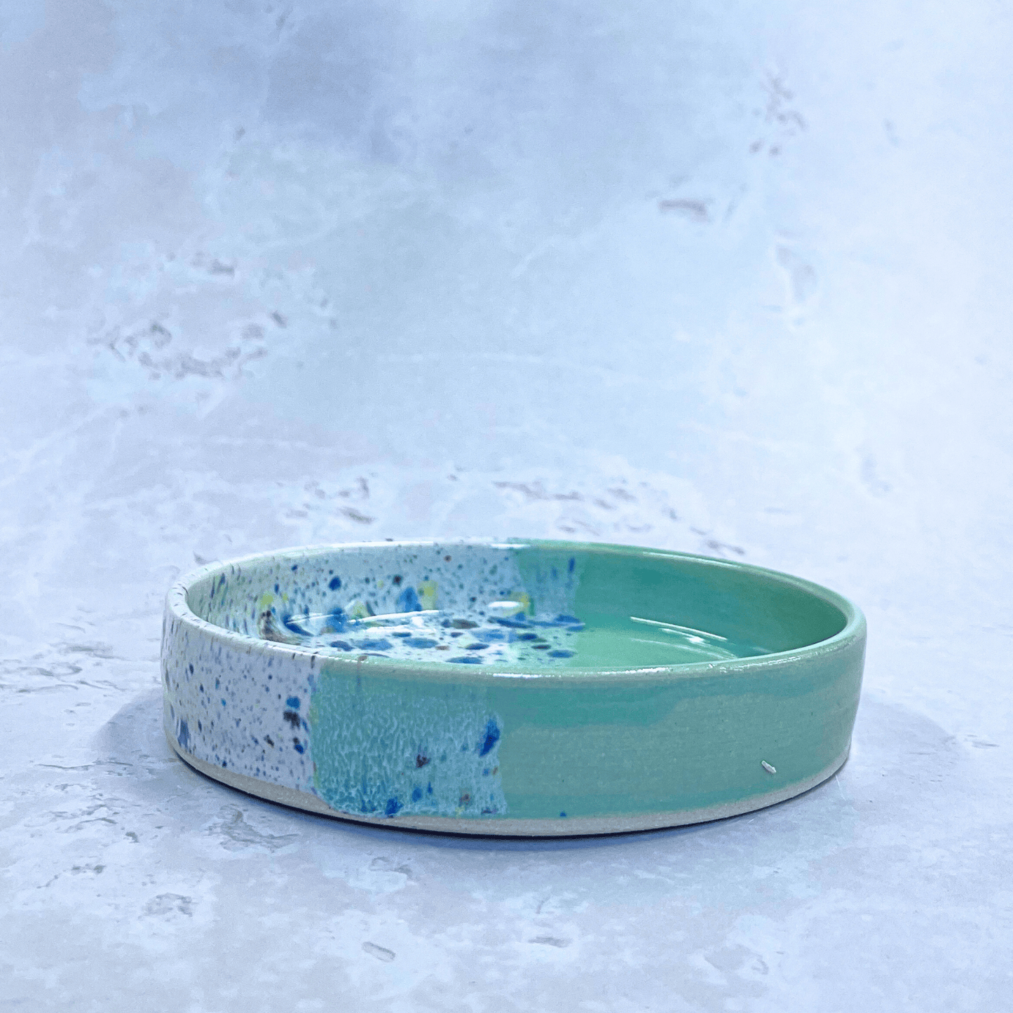 Ella Fletcher Designs Handmade Ceramics Trinket Dish in Green Shoreline Design, side view of small round green and multicolour speckled dish