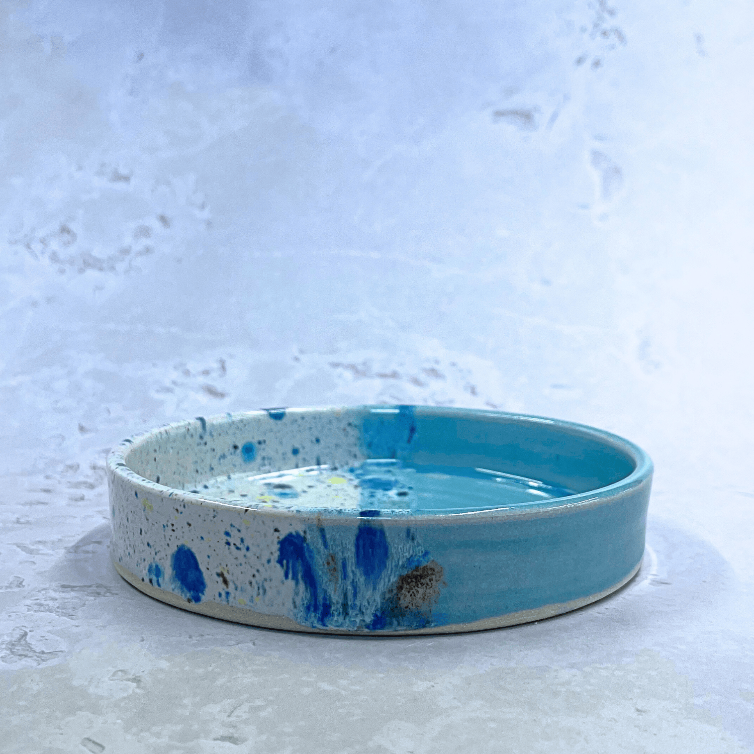 Ella Fletcher Designs Handmade Ceramics Trinket Dish in Pale Blue Shoreline Design, side view of small round pale blue and multicolour speckles dish 