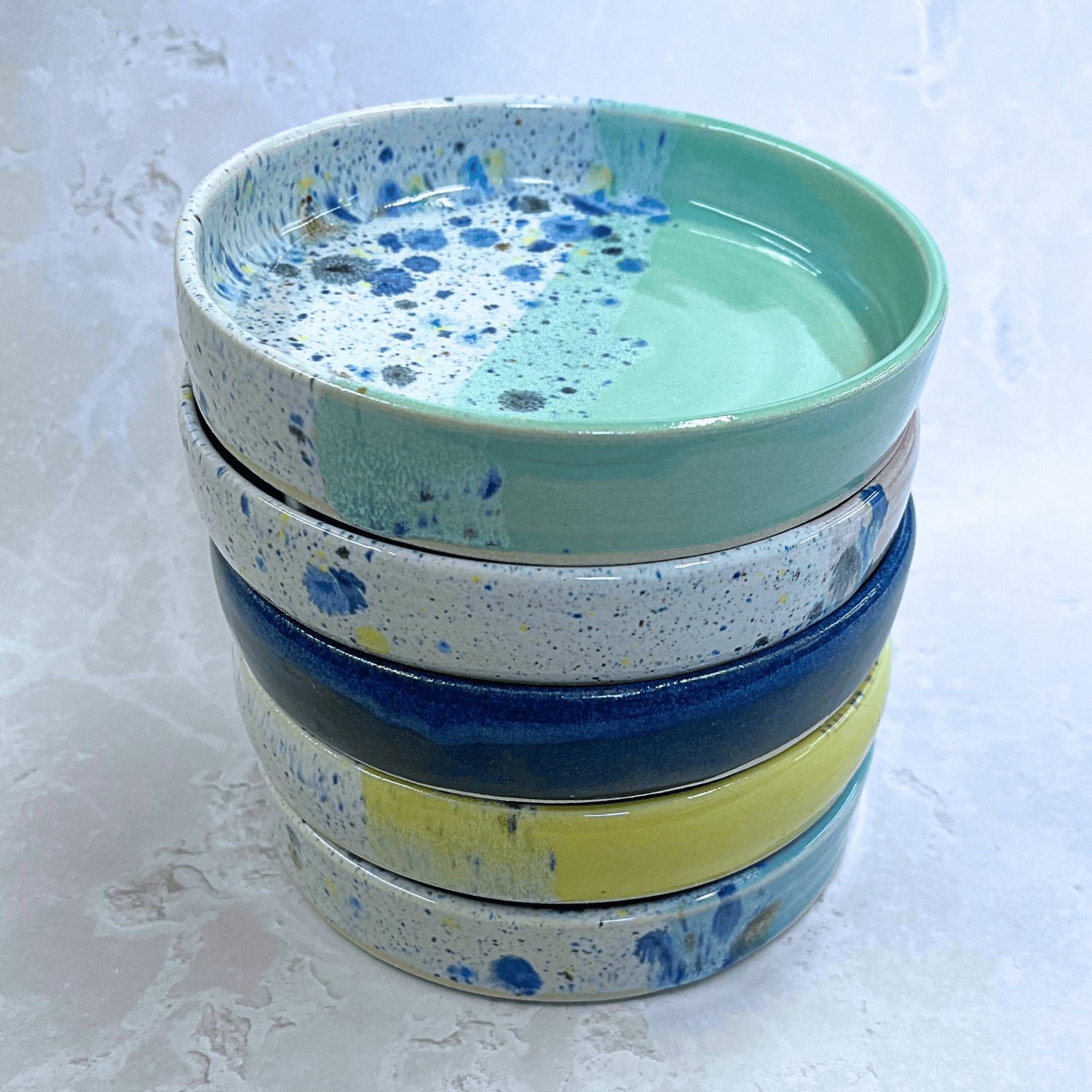 Ella Fletcher Designs Handmade Ceramic Trinket Dishes in Shoreline Design, small round dishes with solid colors and multicolour speckles, stacked 