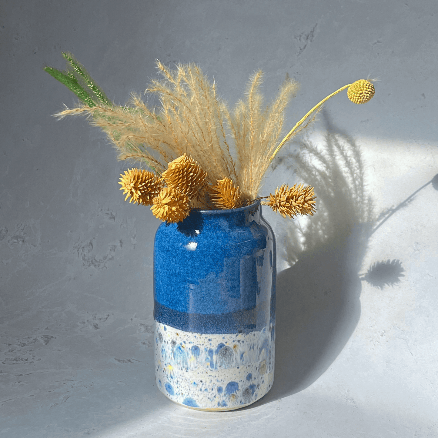 Ella Fletcher Designs Handmade Ceramic Vase in Navy Shoreline Design, navy upper half with multi-coloured speckles on bottom half featuring flowers